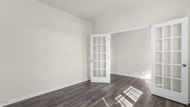 empty room with dark wood-type flooring, french doors, and baseboards