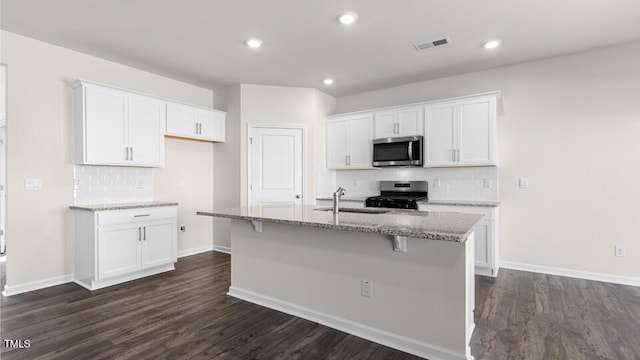 kitchen with visible vents, white cabinets, appliances with stainless steel finishes, and a sink