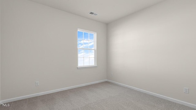 unfurnished room with baseboards, visible vents, and light carpet