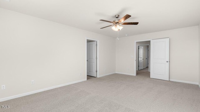 spare room with baseboards, light carpet, and ceiling fan