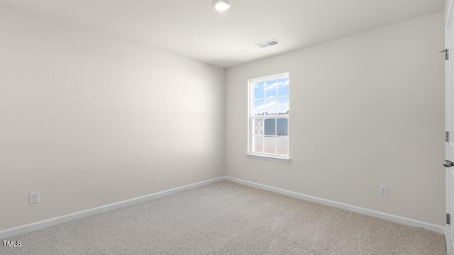 empty room featuring visible vents, light carpet, and baseboards