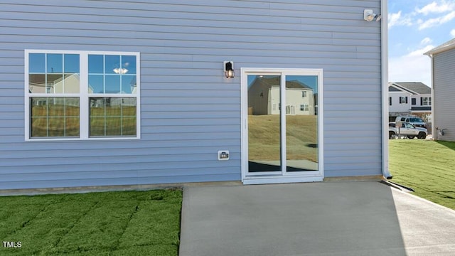 doorway to property featuring a patio and a yard