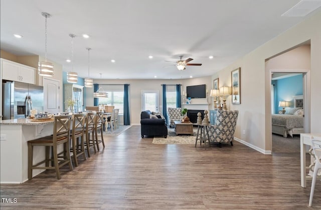 living room with ceiling fan and dark hardwood / wood-style flooring