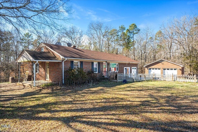 single story home with a garage, an outbuilding, and a front yard