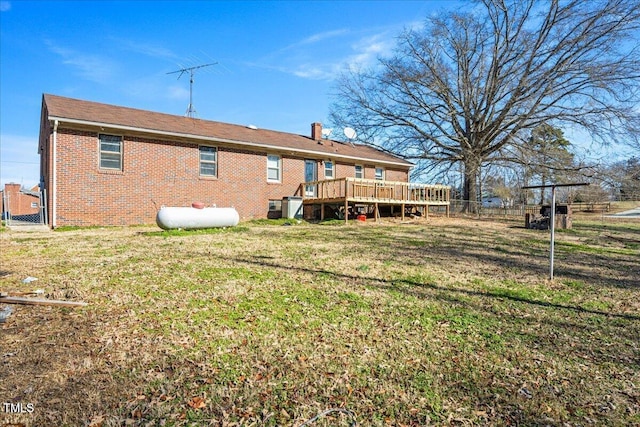 rear view of property with a lawn and a deck