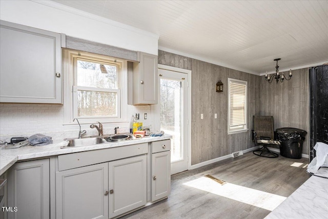 kitchen with light hardwood / wood-style flooring, an inviting chandelier, plenty of natural light, and sink