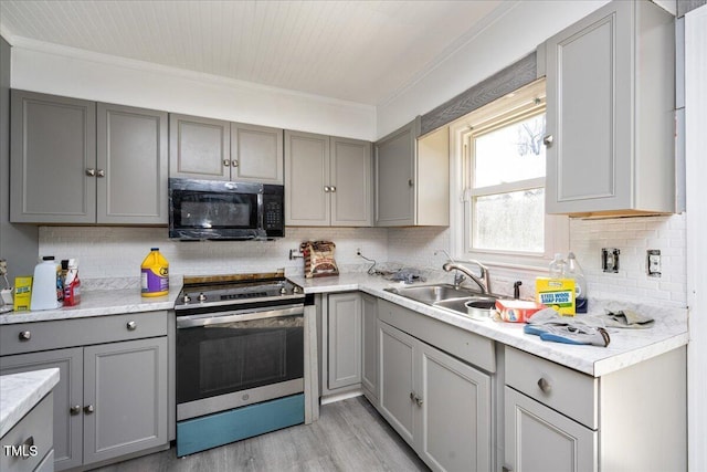 kitchen featuring gray cabinetry, stainless steel electric range, crown molding, and sink