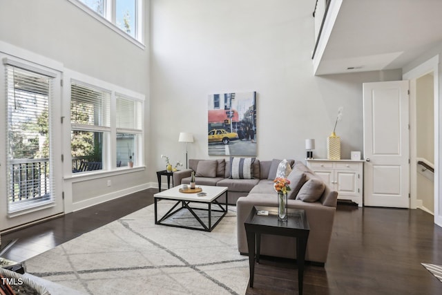 living room with a wealth of natural light and dark wood-type flooring