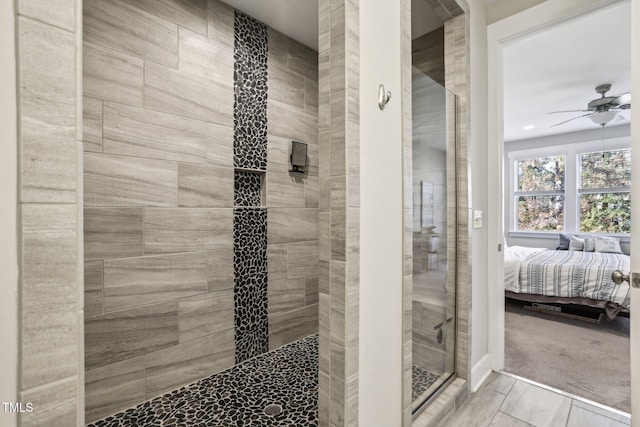 bathroom with a tile shower and ceiling fan