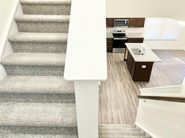 stairway featuring sink and hardwood / wood-style floors