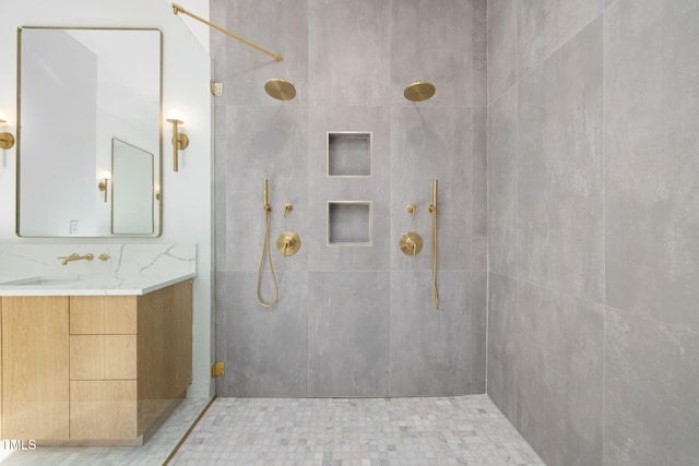 bathroom featuring a tile shower and vanity