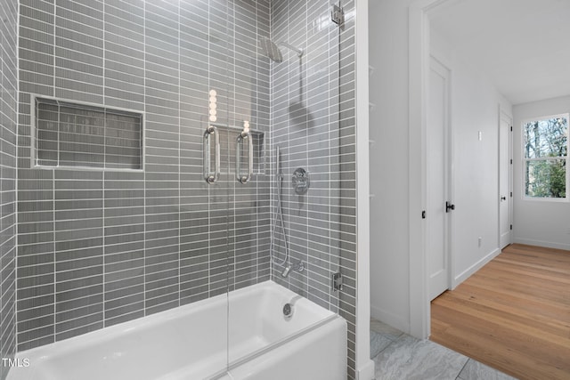 bathroom with hardwood / wood-style floors and enclosed tub / shower combo