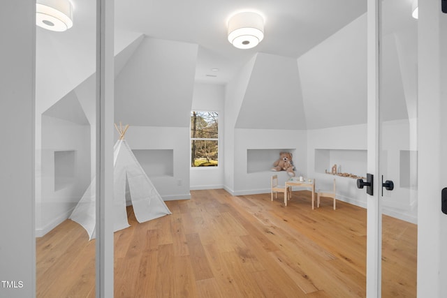 interior space featuring wood-type flooring and vaulted ceiling