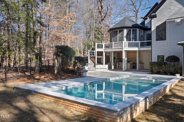 view of swimming pool with a patio and a sunroom