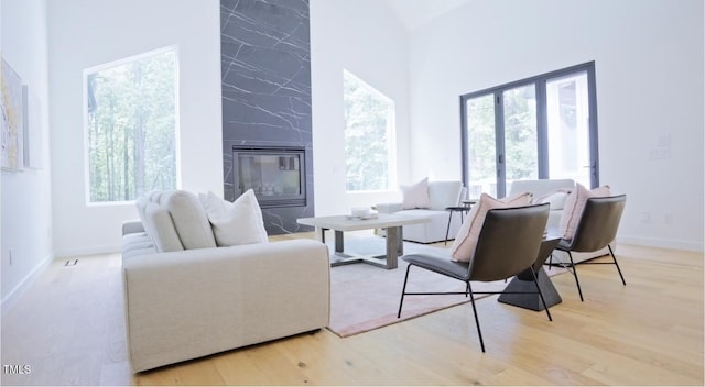 living room with plenty of natural light, wood finished floors, and a premium fireplace