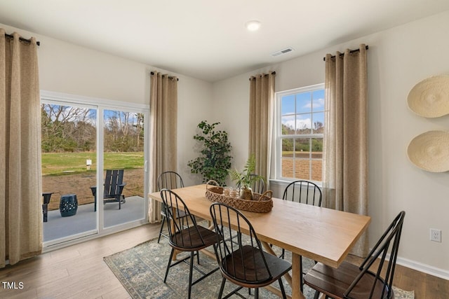 dining space with wood-type flooring