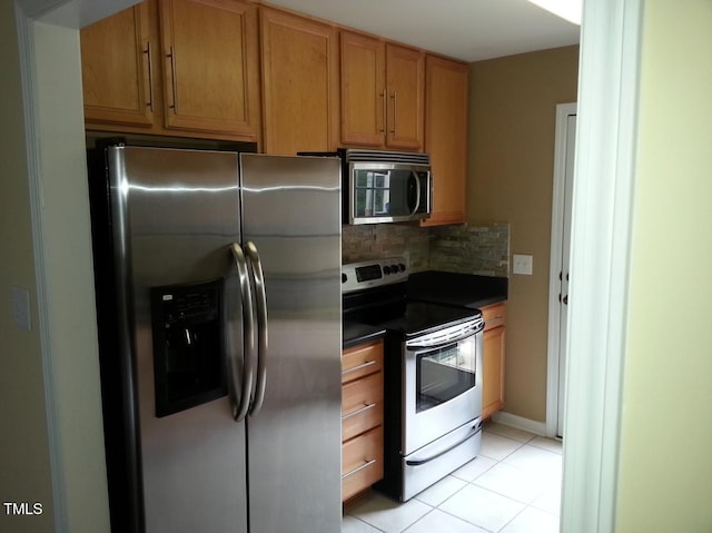 kitchen with decorative backsplash, appliances with stainless steel finishes, and light tile patterned floors