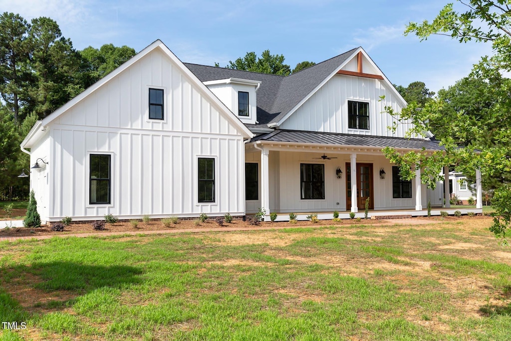 modern inspired farmhouse featuring a porch and a front yard