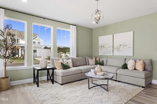 living room with light hardwood / wood-style floors and an inviting chandelier