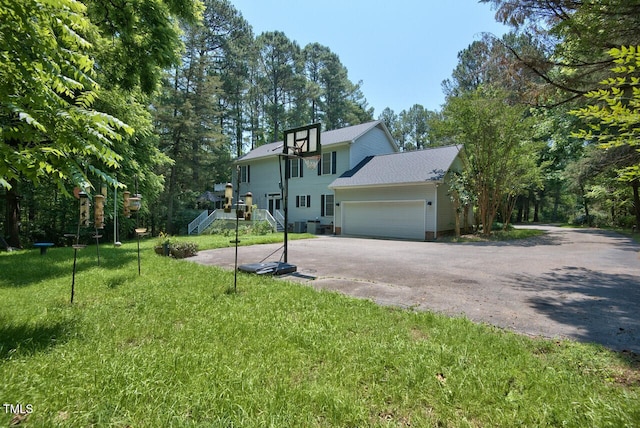 view of front of house featuring an attached garage, a front lawn, and aphalt driveway