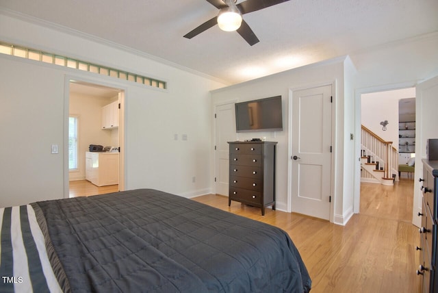 bedroom featuring light wood-type flooring, ornamental molding, independent washer and dryer, and baseboards