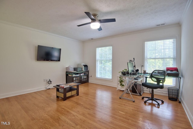 office area with a textured ceiling, wood finished floors, visible vents, a ceiling fan, and ornamental molding