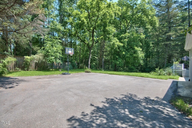 view of patio / terrace with basketball hoop and fence