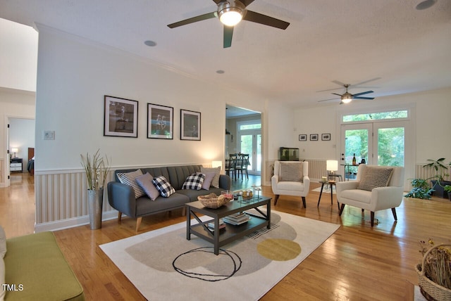 living area featuring light wood-style floors, ceiling fan, and radiator heating unit