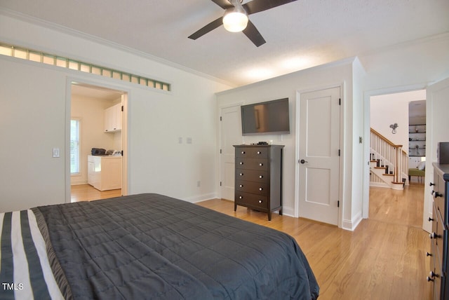 bedroom featuring crown molding, washer and dryer, baseboards, a ceiling fan, and light wood finished floors