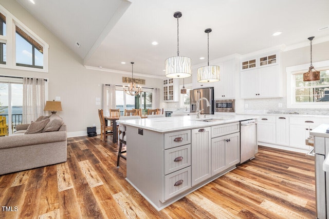 kitchen featuring a center island with sink, wood-type flooring, white cabinetry, and stainless steel appliances