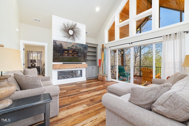 living room with wood-type flooring and high vaulted ceiling