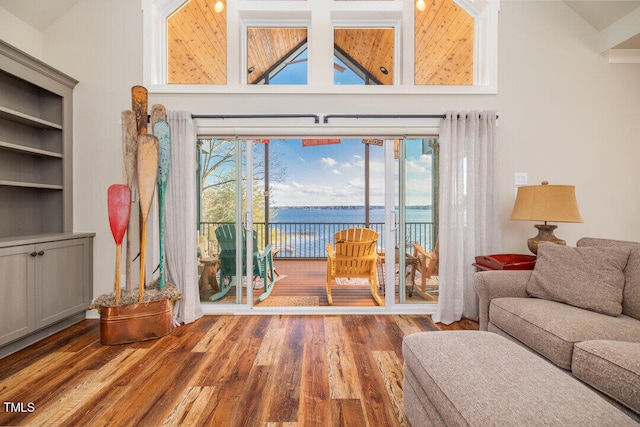 living room featuring hardwood / wood-style flooring, built in shelves, and a water view