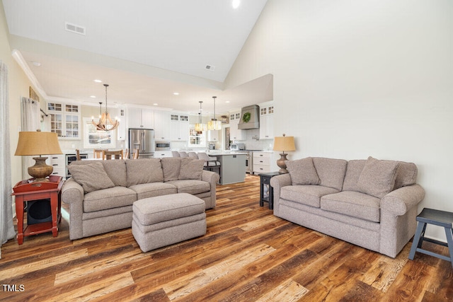 living room featuring dark hardwood / wood-style floors, high vaulted ceiling, and a chandelier