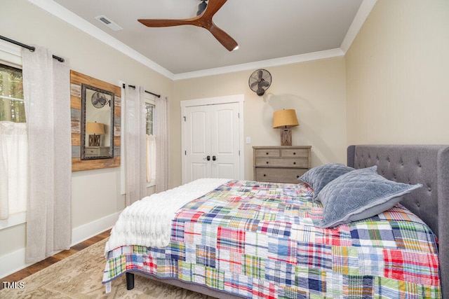 bedroom featuring ceiling fan, wood-type flooring, crown molding, and a closet