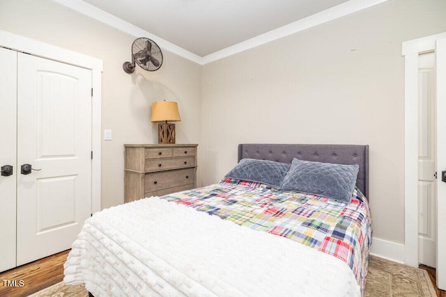 bedroom with crown molding, a closet, and hardwood / wood-style flooring