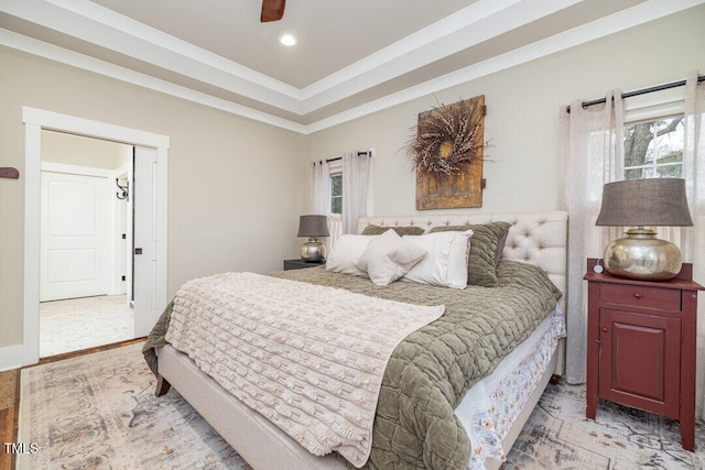 bedroom with light hardwood / wood-style floors, a raised ceiling, ceiling fan, and ornamental molding