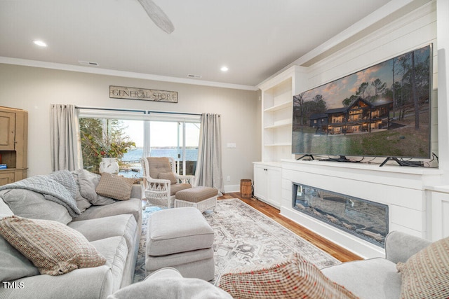 living room featuring wood-type flooring and crown molding