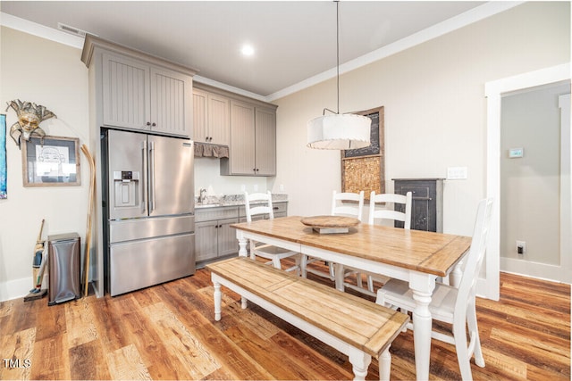 kitchen with gray cabinetry, light hardwood / wood-style floors, crown molding, and high quality fridge