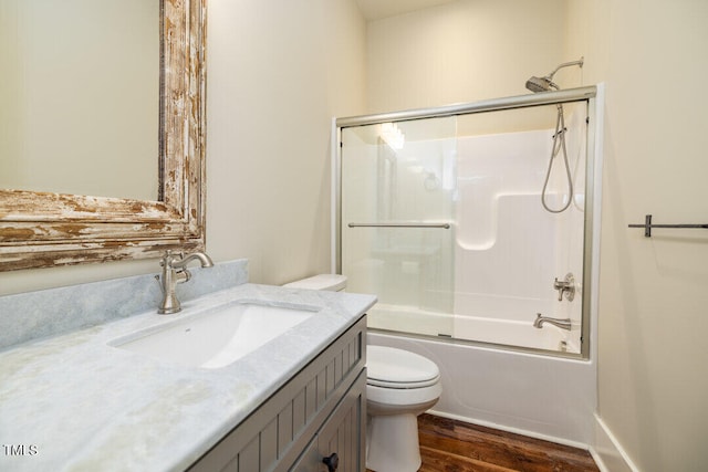 full bathroom featuring combined bath / shower with glass door, wood-type flooring, vanity, and toilet