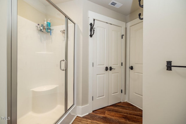 bathroom featuring hardwood / wood-style floors and an enclosed shower