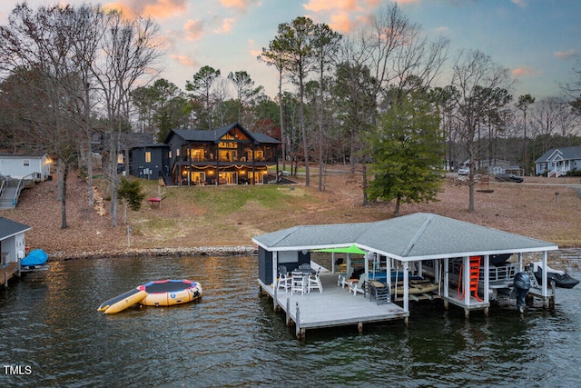 view of dock featuring a lawn and a water view