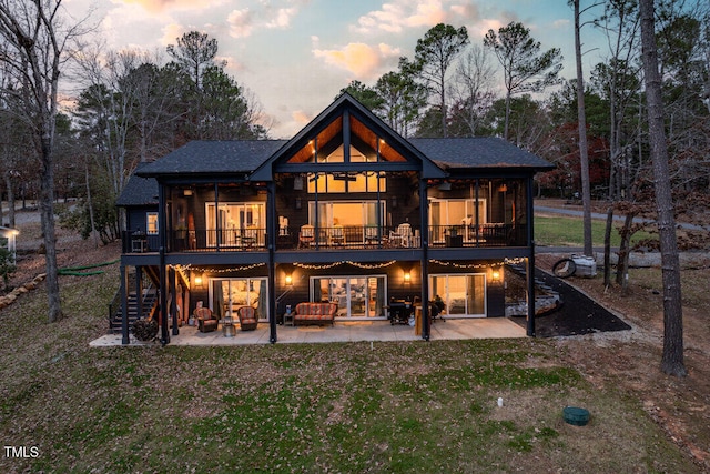 back house at dusk featuring an outdoor hangout area and a patio area