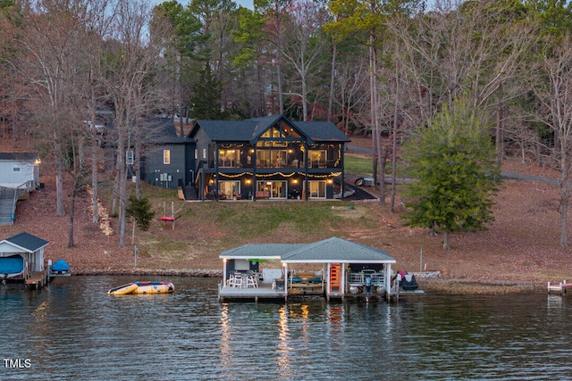 rear view of house with a lawn and a water view