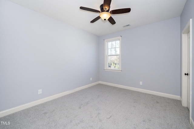 empty room with light carpet, a ceiling fan, visible vents, and baseboards