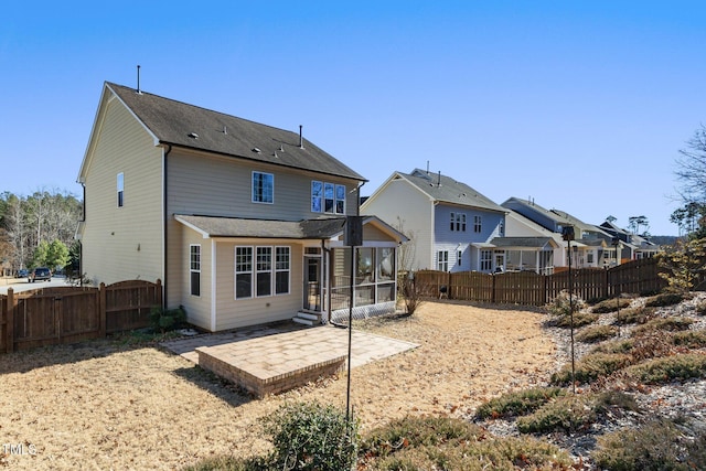 rear view of house with a patio area, a fenced backyard, a residential view, and a sunroom