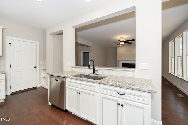 kitchen with dark wood-style flooring, a sink, white cabinetry, light stone countertops, and dishwasher