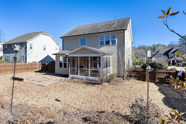 rear view of property with a sunroom, a fenced backyard, a residential view, and a patio