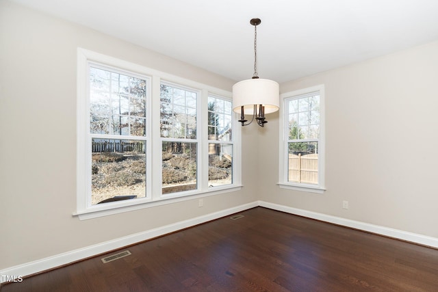 unfurnished dining area with visible vents, baseboards, and wood finished floors