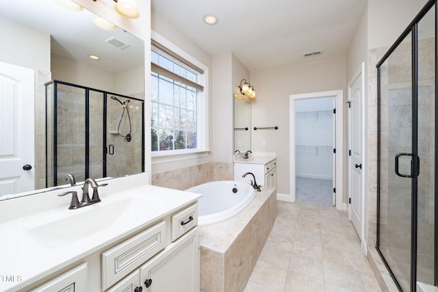 full bath featuring two vanities, visible vents, a stall shower, a sink, and a bath