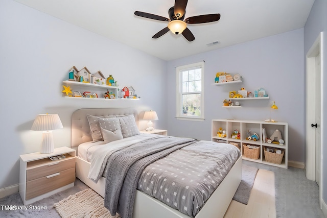 bedroom featuring light carpet, baseboards, visible vents, and a ceiling fan